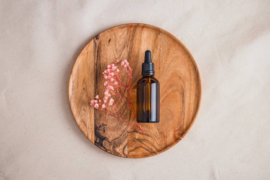 Close-up of premium beard oil bottle with natural ingredients and grooming tools on a wooden background