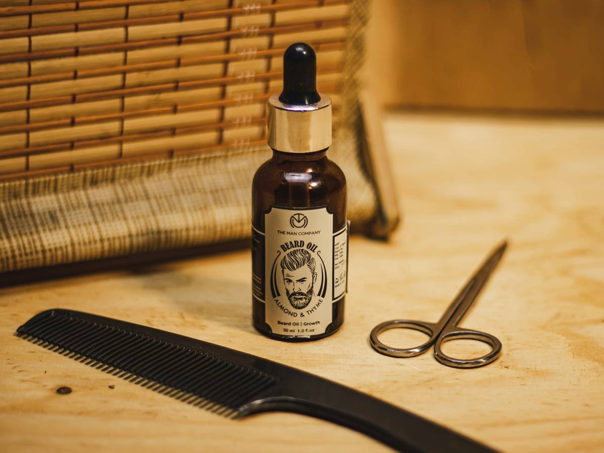 Chart comparing comedogenic ratings of common beard oil ingredients: jojoba (2), argan (0), grapeseed (1), coconut (4), castor (1)